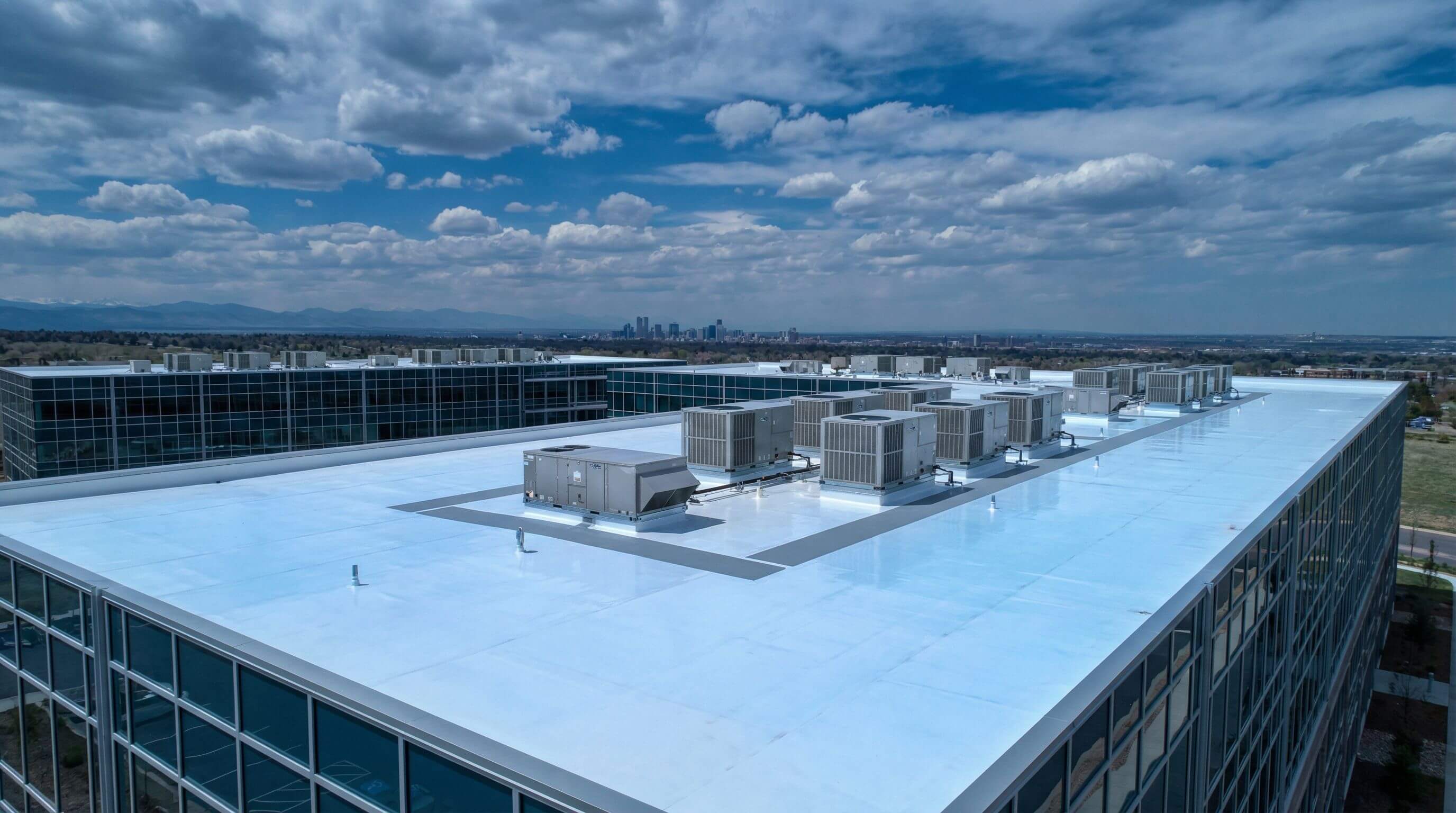 Commercial roofing specialists installing TPO membrane on flat roof